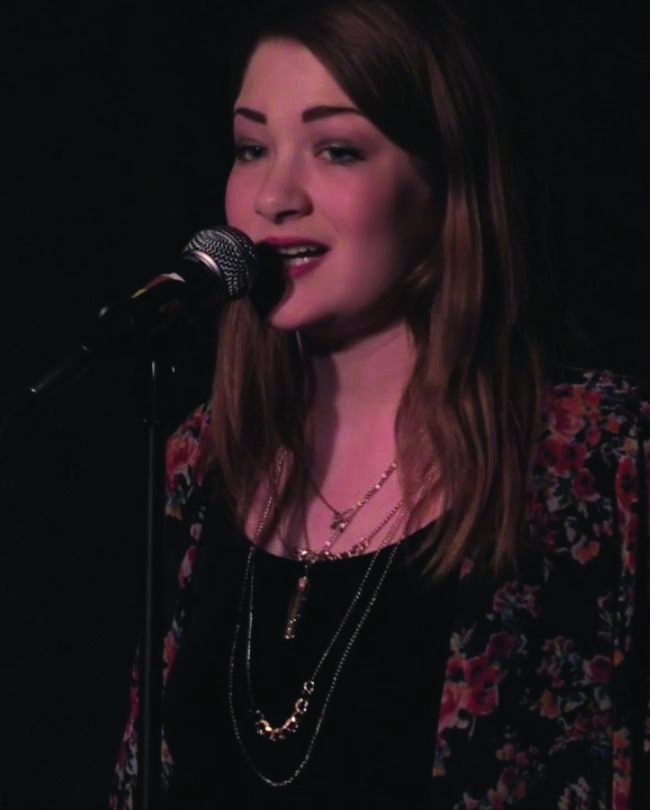 Spoken word poet Blythe Baird performing in front of a microphone