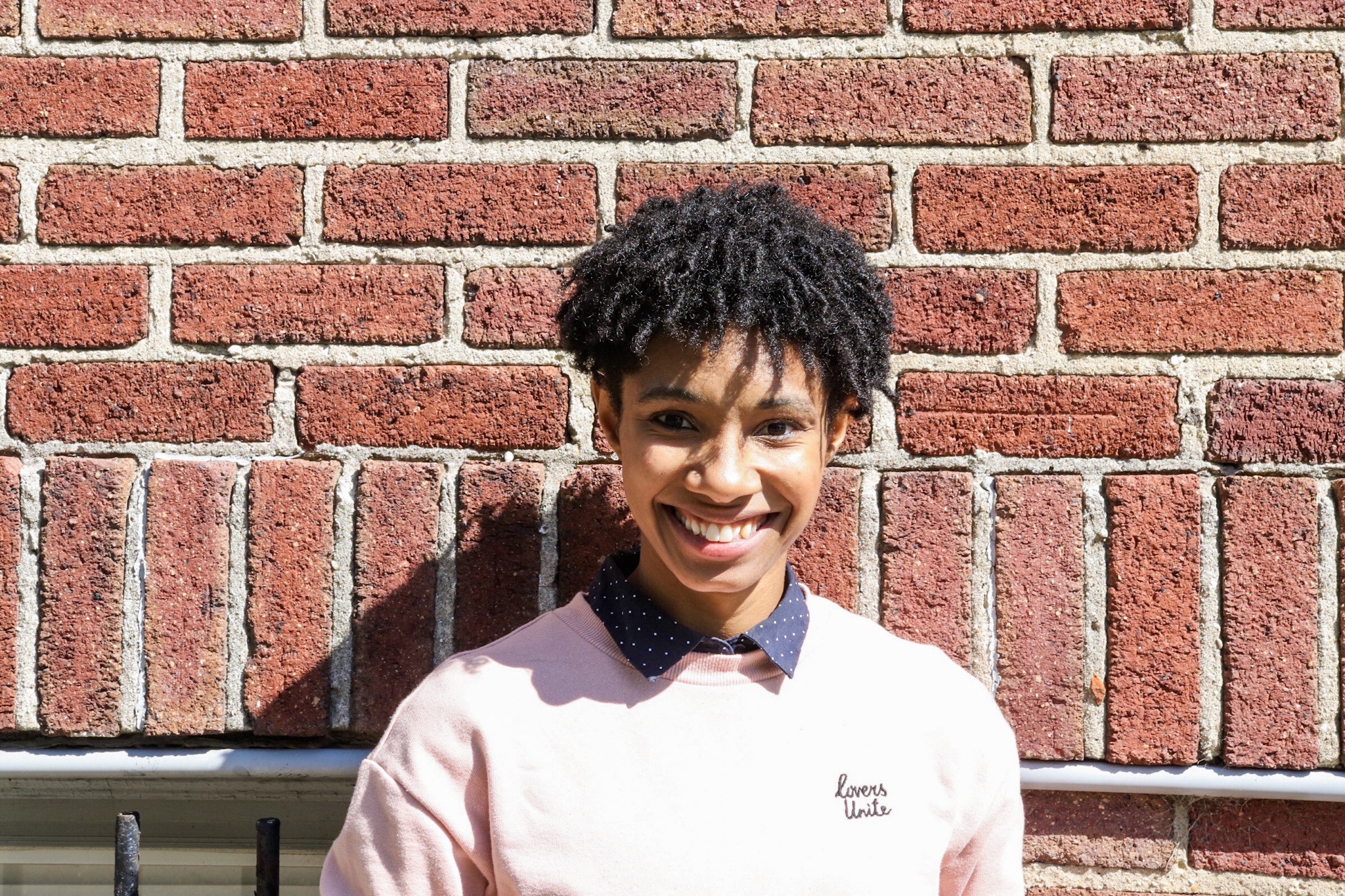 Book blogger August standing in front of a brick wall