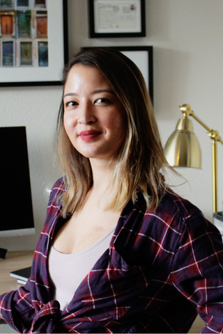 Marianna Manzler sitting in front of her computer, smiling at the camera