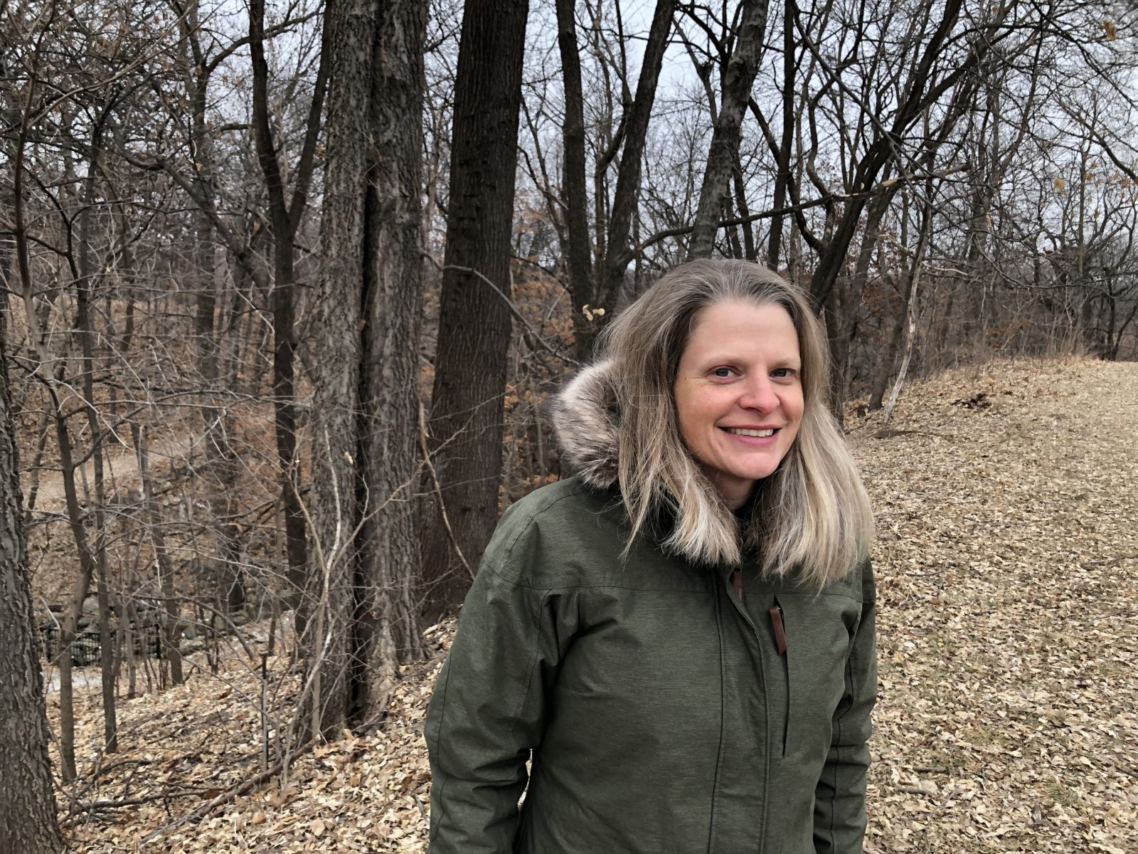 Headshot of teaching artist Sara Puotinen standing outside in the woods