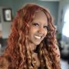 headshot of a bi-racial woman with reddish hair who is smiling